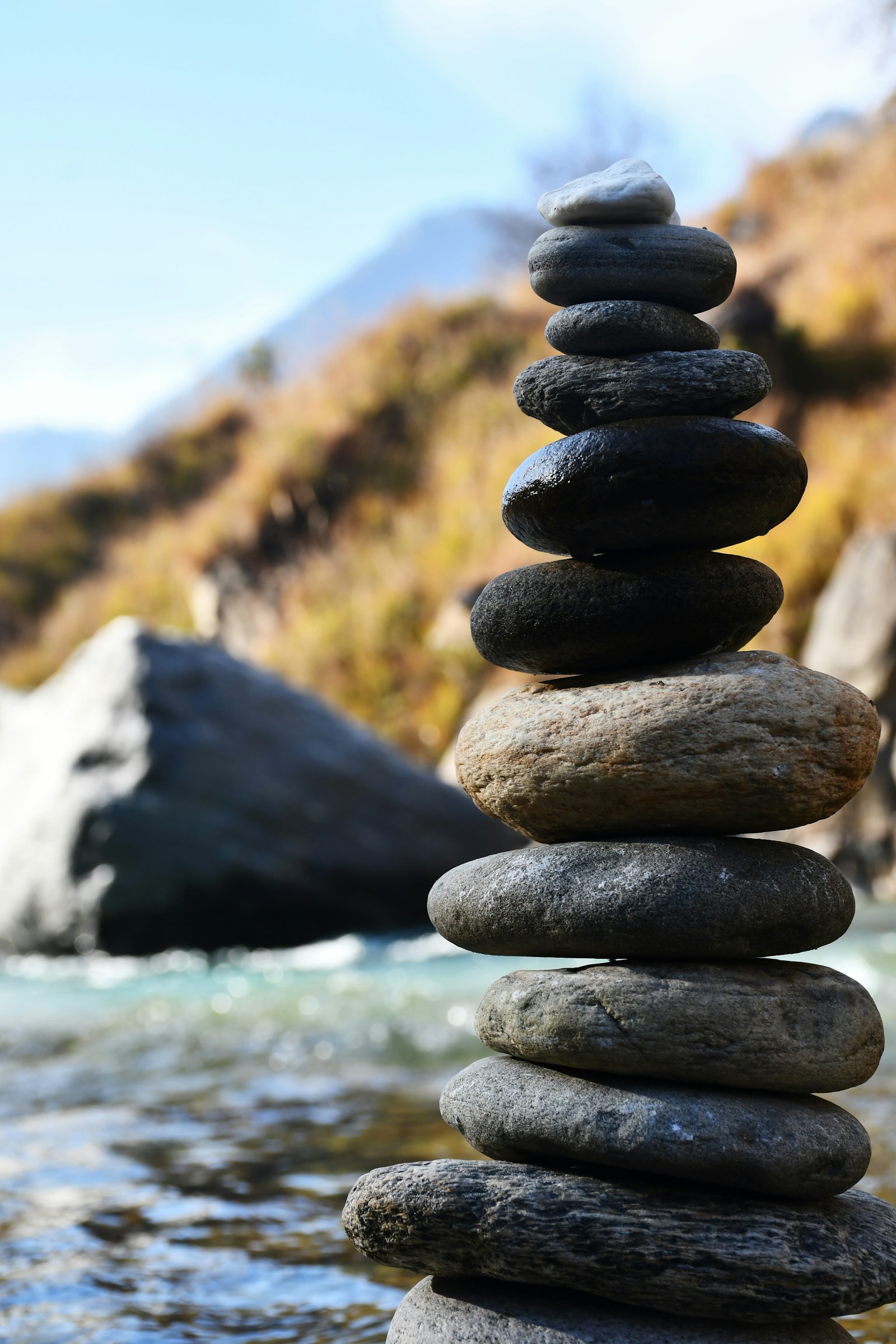 A cairn of stacked stones at the edge of a mountain river